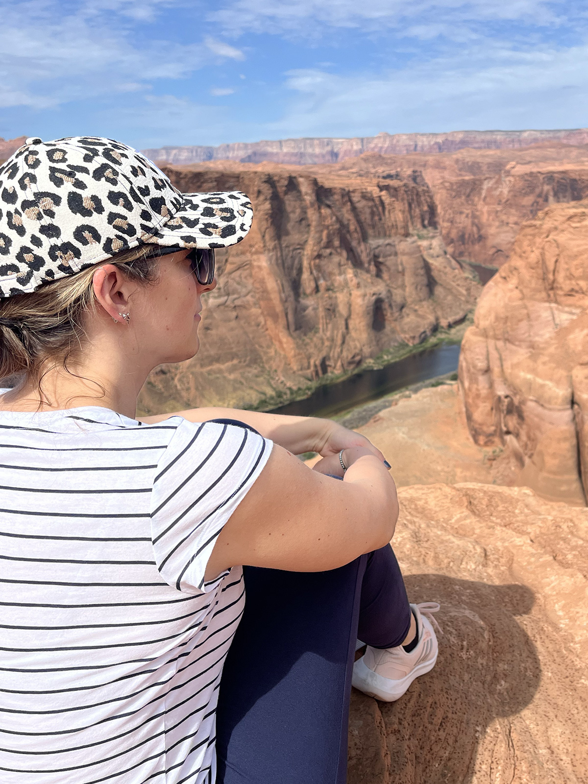 Lia seduta sul bordo dell'Horseshoe Bend, canyon a forma di ferro di cavallo in Arizona (USA)